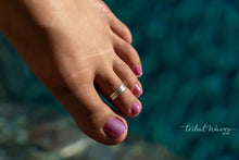 Load image into Gallery viewer, gold and silver toe ring on a second toe over a blue pool.