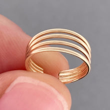 Load image into Gallery viewer, A close-up of a gold ear cuff being held between two fingers against a neutral gray background.